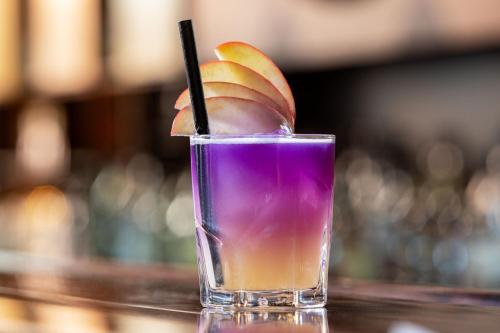 a purple drink with an orange slice in a glass at Sheraton Hannover Pelikan Hotel in Hannover