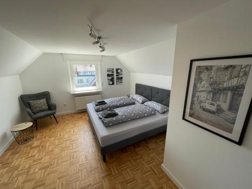 a bedroom with a bed and a chair in it at Altstadt Maisonette Wohnung in Brilon