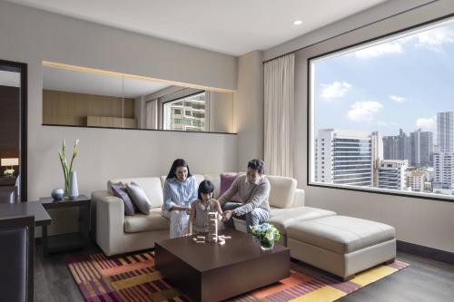 two women and a child sitting in a living room at Marriott Executive Apartments Sukhumvit Park, Bangkok in Bangkok