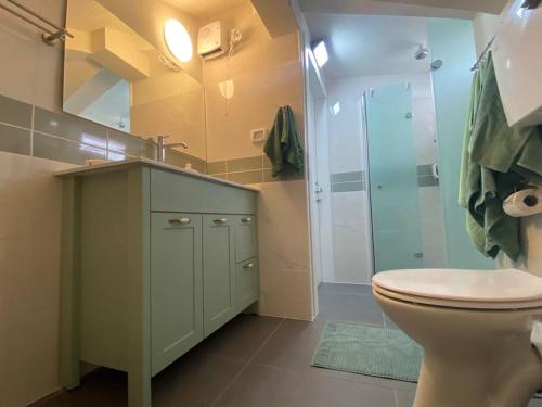 uma casa de banho com um WC e uma cabina de duche em vidro. em קומותיים ברמה em Sha'al