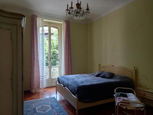 a bedroom with a bed and a window and a chandelier at Croisette in Turin