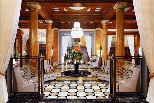 una hall con tavolo, sedie e lampadario pendente di The Westin Excelsior, Florence a Firenze