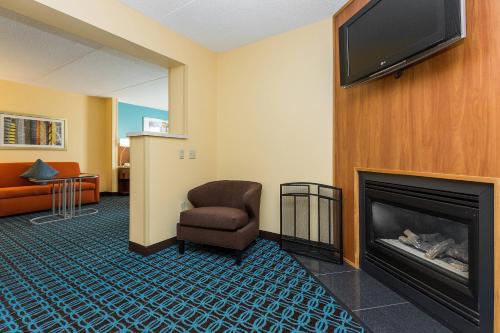 a waiting room with a chair and a fireplace at Fairfield Inn & Suites Des Moines West in West Des Moines