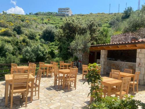 a row of wooden tables and chairs on a patio at Hotel Mesun Himare in Himare