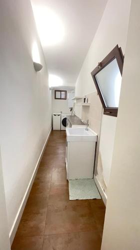 a white bathroom with a sink and a mirror at Maison 57 in Brindisi
