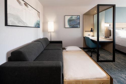 a living room with a couch and a bed and a desk at SpringHill Suites by Marriott Valencia in Valencia