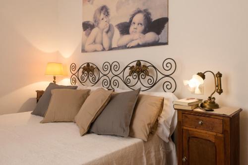 1 dormitorio con 1 cama blanca grande y cabecero en B&B Villa il Poggetto, en Venturina Terme