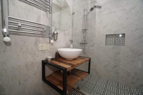 a bathroom with a bowl sink on a wooden table at Green Hotel in Abastumani