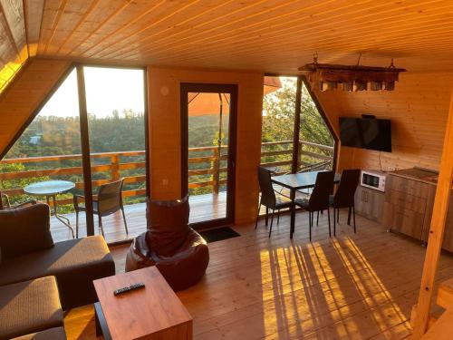 a living room with a fireplace and a table with chairs at Beautiful Wooden house with seaside views in Batumi