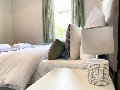 a bedroom with a bed and a table with a lamp at 8 Margaret Road, Whitley Bay in Whitley Bay