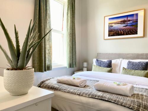 sypialnia z 2 łóżkami i doniczką w obiekcie 8 Margaret Road, Whitley Bay w mieście Whitley Bay