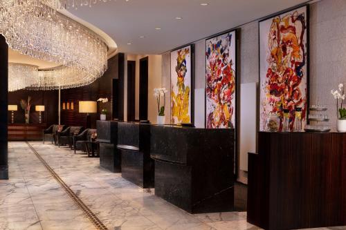 a hotel lobby with a bar with chairs and paintings at JW Marriott Hotel Frankfurt in Frankfurt/Main