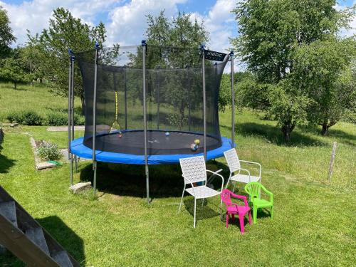 a trampoline in a yard with two chairs at Ferien im Schwarzwald - Ruhe & naturverbunden in Weilheim