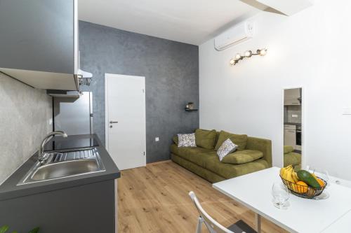 a kitchen and a living room with a couch at Stunning apartment in quiet street near center With free parking 4 floor in Rijeka