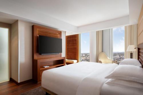 a hotel room with a bed and a flat screen tv at JW Marriott Hotel Frankfurt in Frankfurt