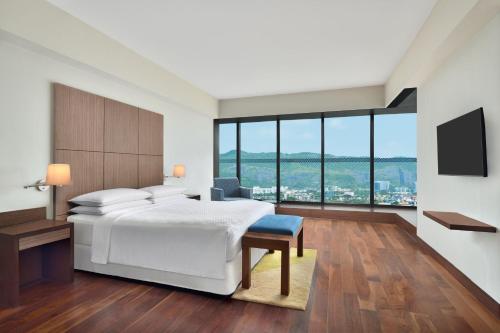a hotel room with a bed and a television at Four Points by Sheraton Navi Mumbai, Vashi in Navi Mumbai