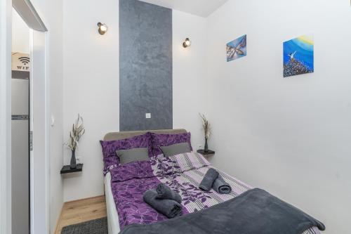 a bedroom with a bed with purple comforter at Stunning apartment in quiet street near center With free parking 4 floor in Rijeka