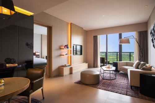 海口的住宿－海口萬麗酒店，客厅配有沙发和桌子