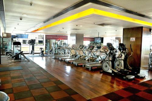a gym with a row of treadmills and cardio machines at Four Points by Sheraton Navi Mumbai, Vashi in Navi Mumbai