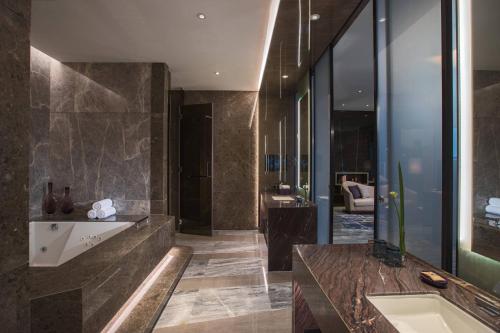 a large bathroom with a tub and a sink at Renaissance Haikou Hotel in Haikou