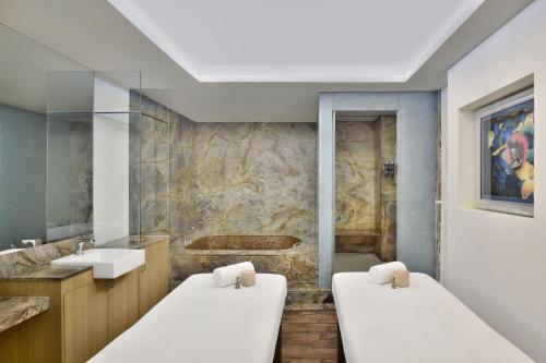 a bathroom with two beds and a sink at Four Points by Sheraton Navi Mumbai, Vashi in Navi Mumbai