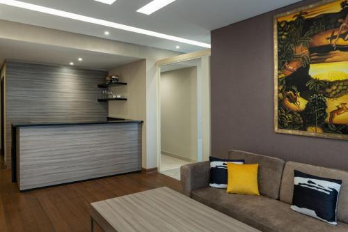 a living room with a couch and a painting on the wall at Four Points by Sheraton Production City, Dubai in Dubai