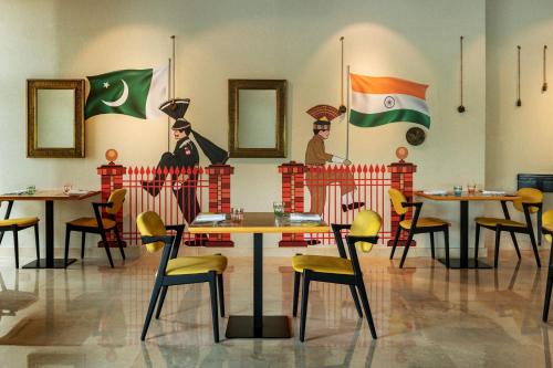 a restaurant with tables and chairs and flags on the wall at Four Points by Sheraton Production City, Dubai in Dubai