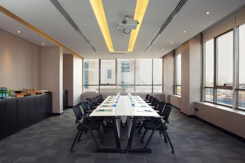 a large conference room with a long table and chairs at Four Points by Sheraton Production City, Dubai in Dubai