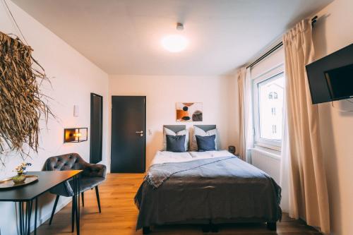 a bedroom with a bed and a table and a window at Premium Apartments Koblenz in Koblenz