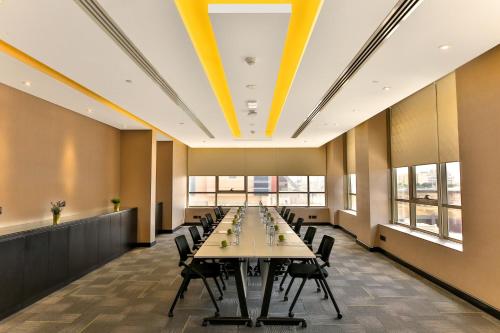 a large conference room with a long table and chairs at Four Points by Sheraton Production City, Dubai in Dubai
