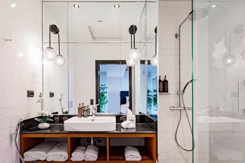 uma casa de banho com um lavatório e um chuveiro em Hotel U14, Autograph Collection em Helsinque
