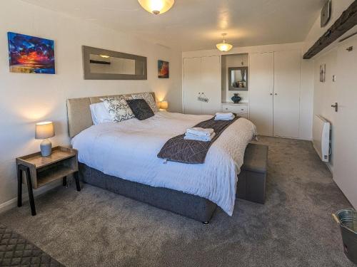 a bedroom with a large bed and a table at The Coach House - Uk38044 in Beetham