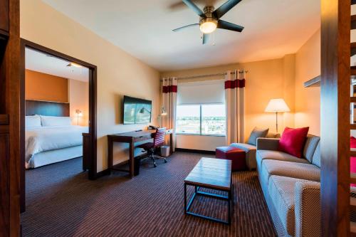 a hotel room with a couch and a bed and a desk at Four Points By Sheraton Houston Energy Corridor in Katy