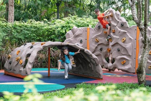 a young girl and boy playing on an outdoor play structure at Sheraton Hua Hin Resort & Spa in Cha Am