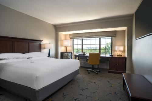 a hotel room with a bed and a desk and a window at Sheraton Baltimore Washington Airport - BWI in Linthicum Heights