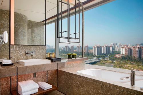 a bathroom with a tub and a large window at Sheraton Guangzhou Nansha Hotel in Guangzhou