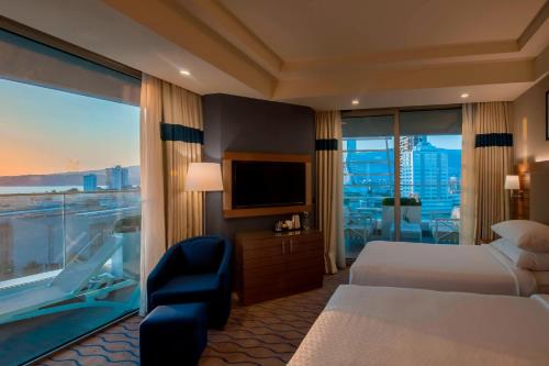 pokój hotelowy z łóżkiem i dużym oknem w obiekcie Four Points by Sheraton Izmir w mieście Izmir