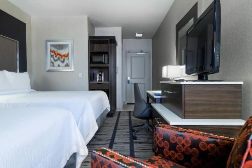 Habitación de hotel con 2 camas y TV de pantalla plana. en Fairfield Inn & Suites by Marriott Boston Cambridge, en Cambridge
