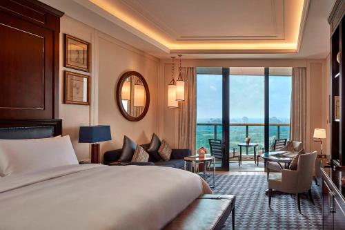 a bedroom with a bed and a living room at The Ritz-Carlton, Haikou in Haikou