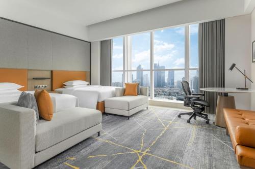 a hotel room with two beds and a desk at Sheraton Guangzhou Hotel in Guangzhou