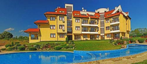 Bliznatsi的住宿－Апартамент в Oasis beach Kamchia - Най-любимото синьо，一座大型建筑,前面设有一个游泳池