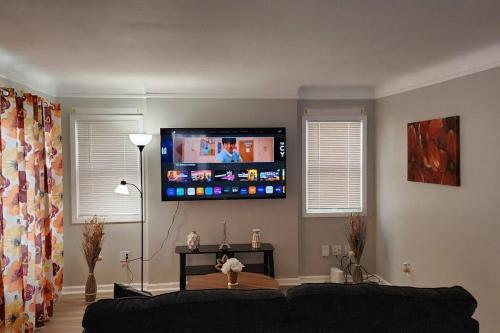 a living room with a couch and a flat screen tv at Beautiful 4 bedroom in Cleveland in Euclid