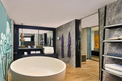 a bathroom with a large tub and a sink at Renaissance Bali Nusa Dua Resort in Nusa Dua