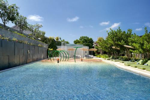 a swimming pool with a playground in a backyard at Renaissance Bali Nusa Dua Resort in Nusa Dua