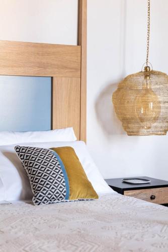 a bedroom with a bed with a pillow and a chandelier at Sella&Mosca Casa Villamarina in Alghero
