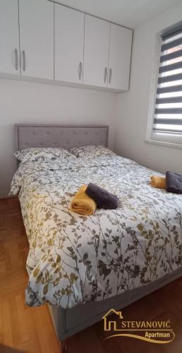 a bed with a comforter and pillows on it at Apartman Stevanovic BN in Bijeljina