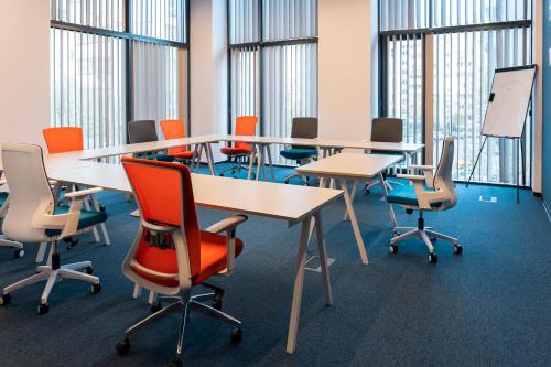 a conference room with tables and chairs and windows at Hotel Campus 90 - Free Parking in Varna City