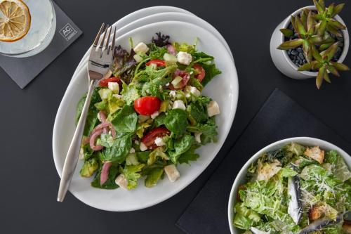 a table with a plate of salad and a bowl of food at AC Hotel by Marriott Orlando Lake Buena Vista in Orlando