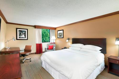 um quarto de hotel com uma cama grande e uma secretária em Four Points by Sheraton Asheville Downtown em Asheville