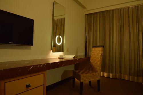a hotel room with a desk with a television and a chair at Kingship Hotel Kaohsiung Inter Continental in Kaohsiung